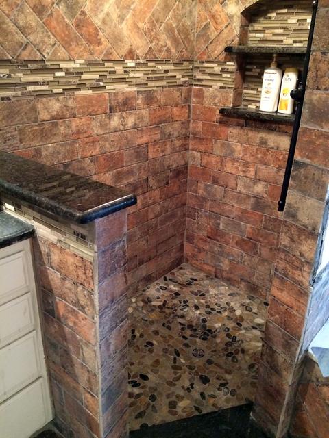 Brick-look tile shower with pebble floor in Arlington